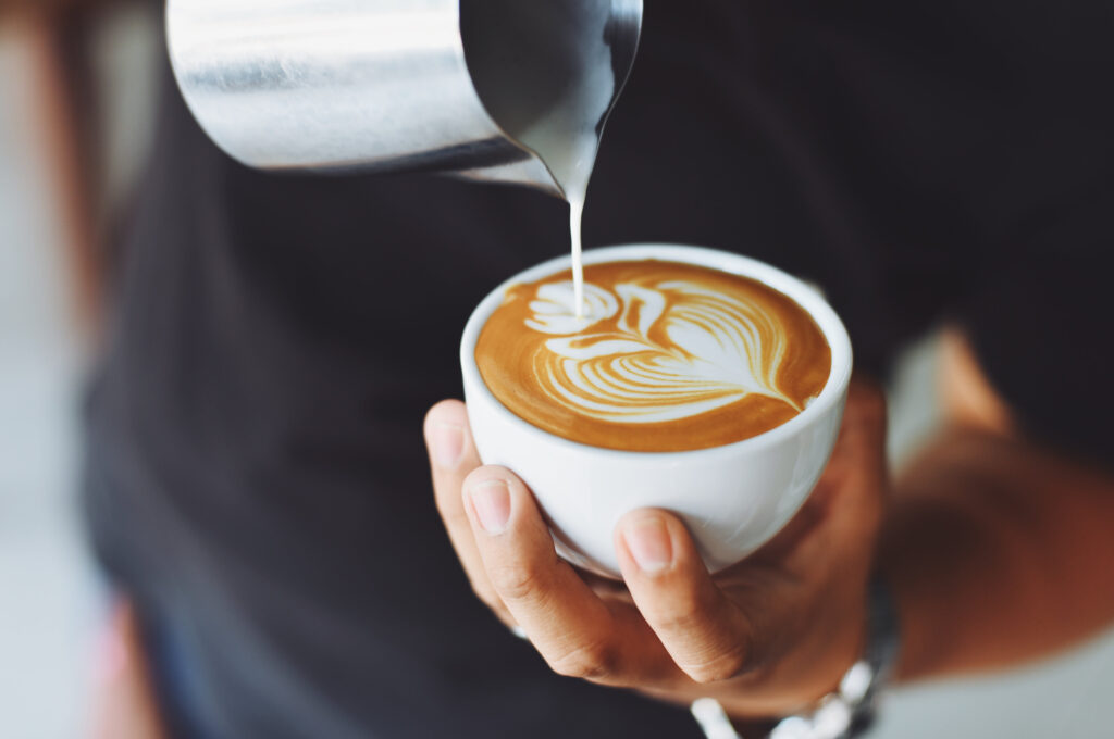 Cafés mit WLAN in Hamburg: Eine Hand hält eine Tasse fest, in die Kaffee eingegossen wird