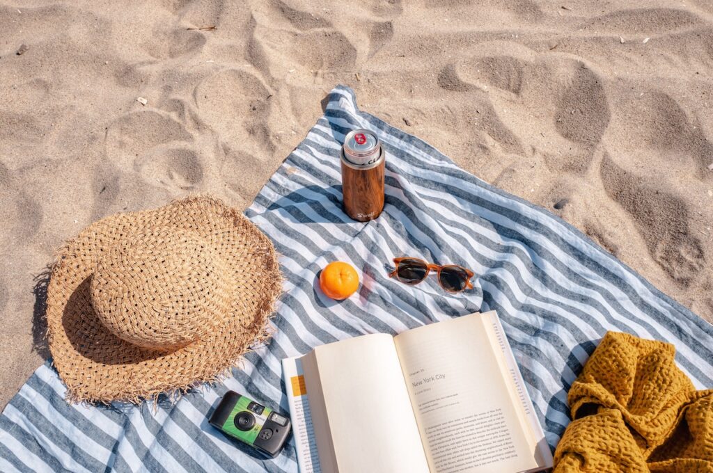 Haspajoker: Ein Strandtuch am Strand mit Hut, Sonnenbrille und vielem mehr