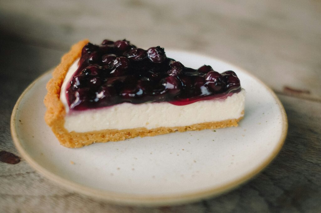 Cheesecake in Hamburg: Ein Stück Käsekluchen mit Heidelbeeren angerichtet