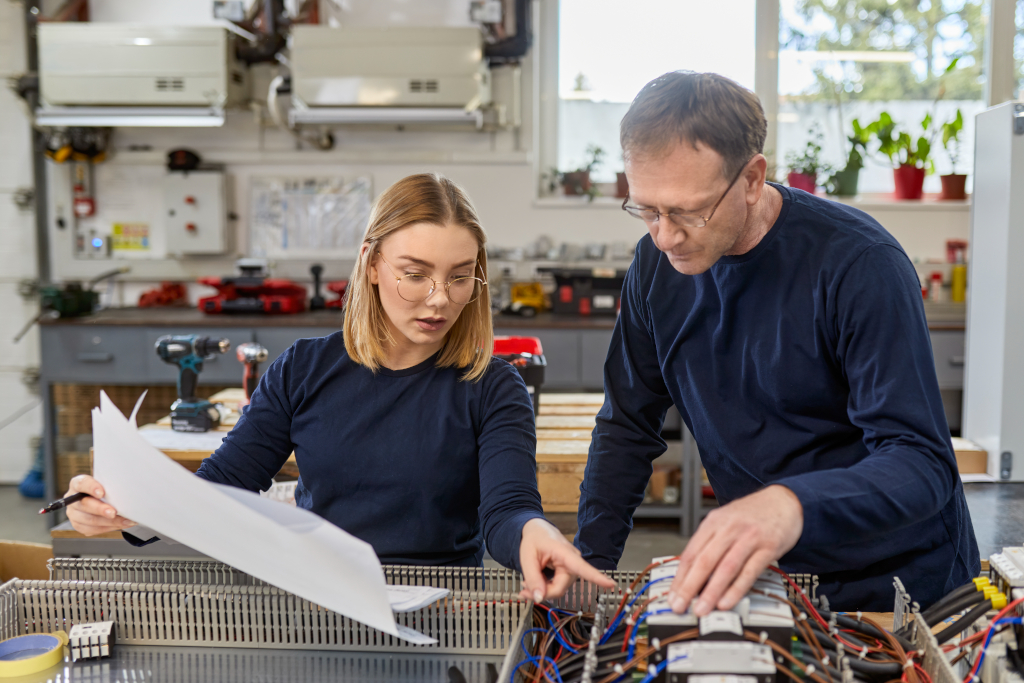 Ausbildung in Hamburg: Elektriker mit Azubine in der Werkstatt