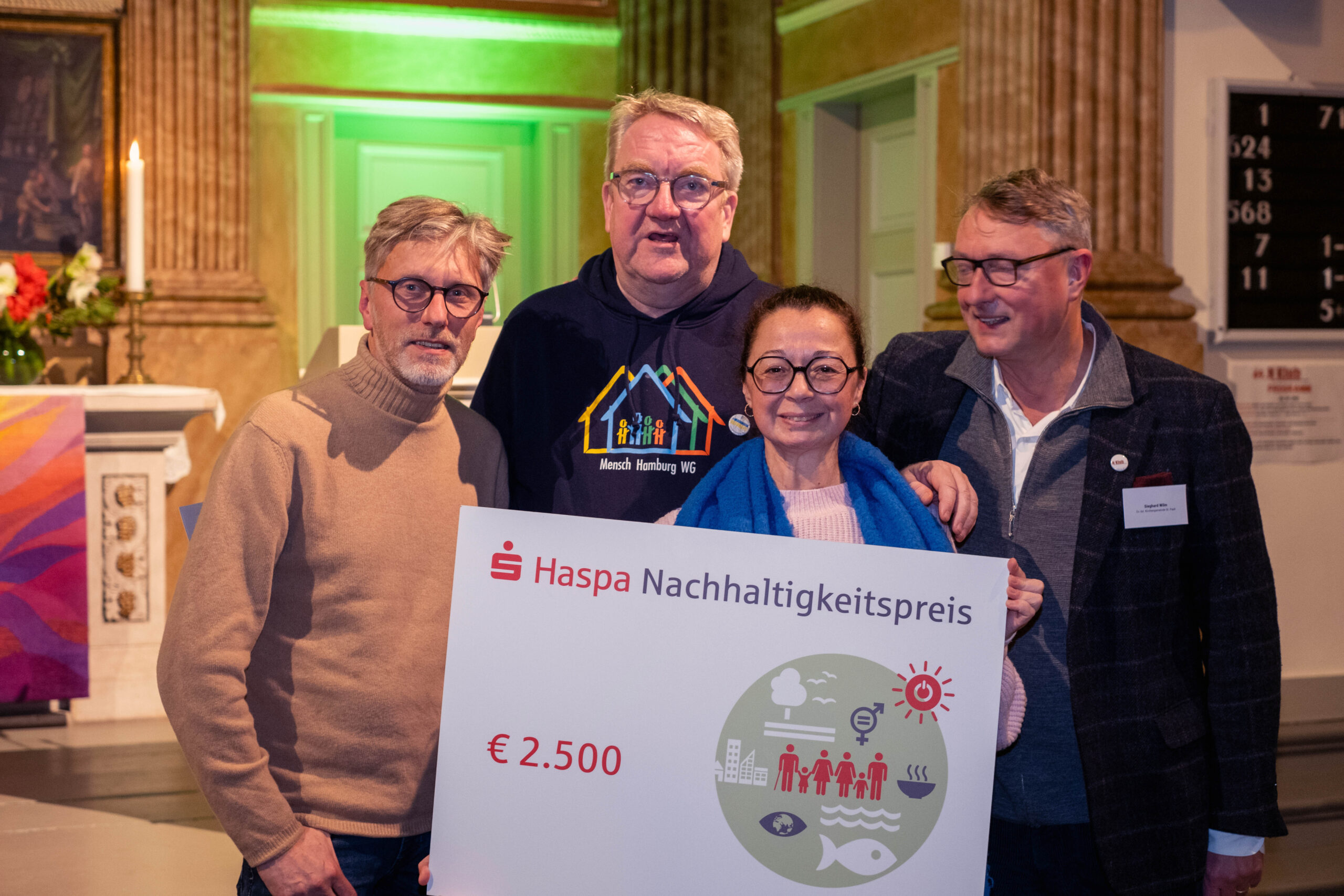 Oll Inklusiv freut sich über den Haspa-Nachhaltigkeitspreis, der beim N Klub im Dezember in der St.Pauli-Kirche überreicht wurde. von links: Marcus-Andree Schoene (Haspa), Lars Meyer (Gute Leude Fabrik) Mitra Kassai (Oll Inklusiv) und Pastor Sieghard Wilm (St. Pauli Kirche)