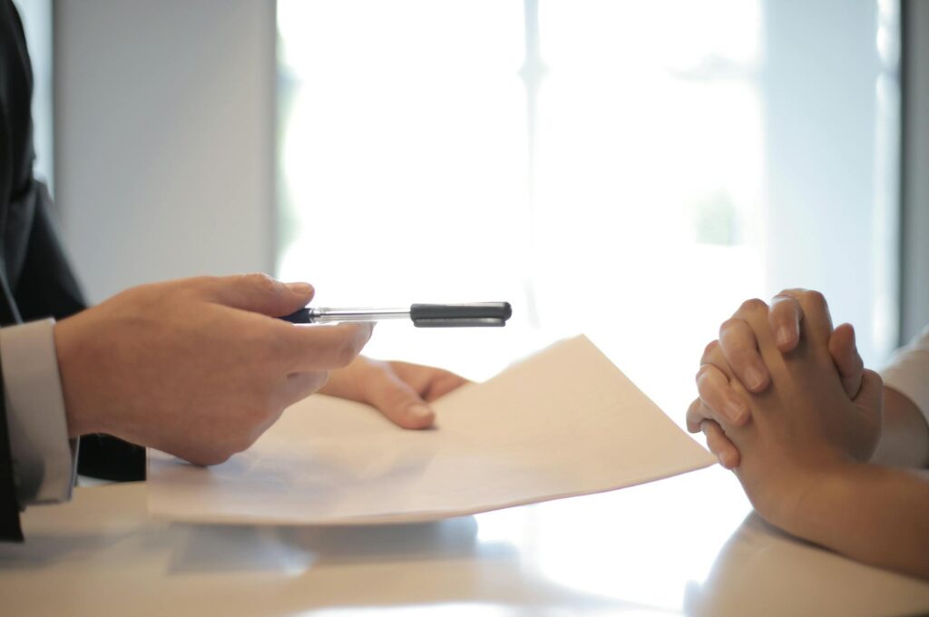 Sondertilgung: Zwei Menschen sitzen an einem Tisch und unterzeichnen einen Vertrag