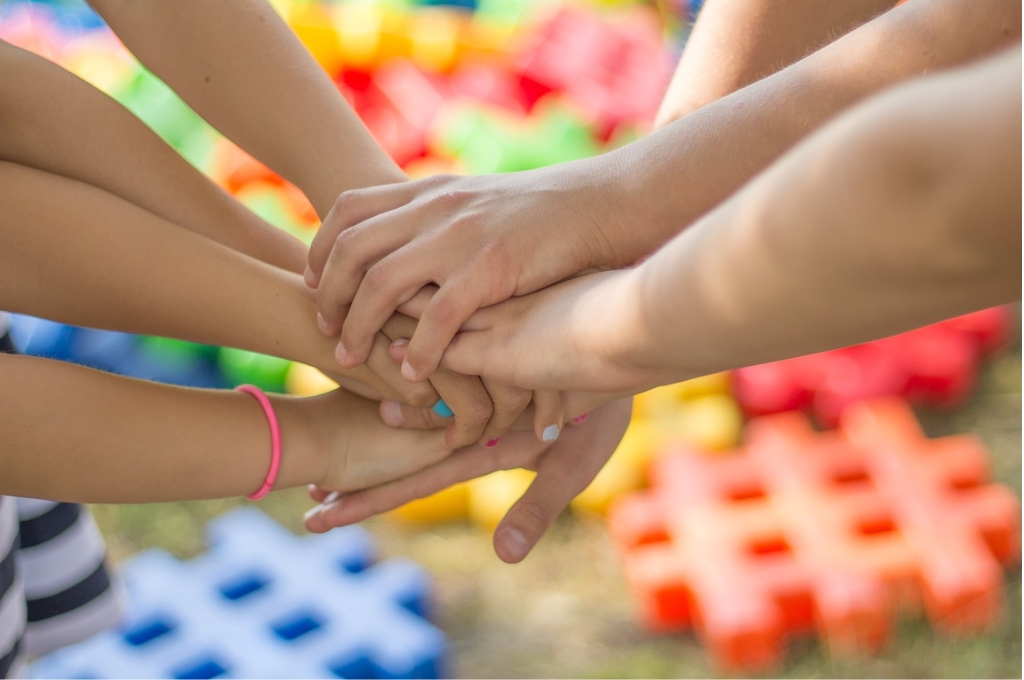 Kinderhände vor buntem Hintergrund