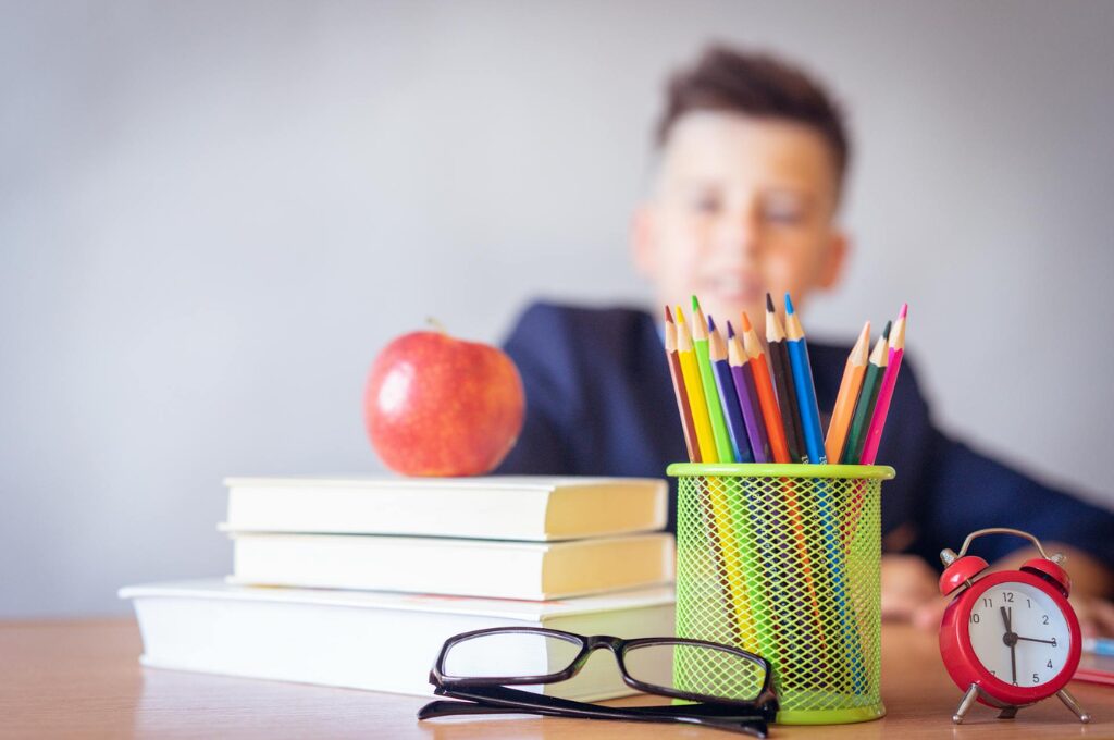 Einschulung: Ein Schüler sitzt in der Schule vor Büchern und Stiften